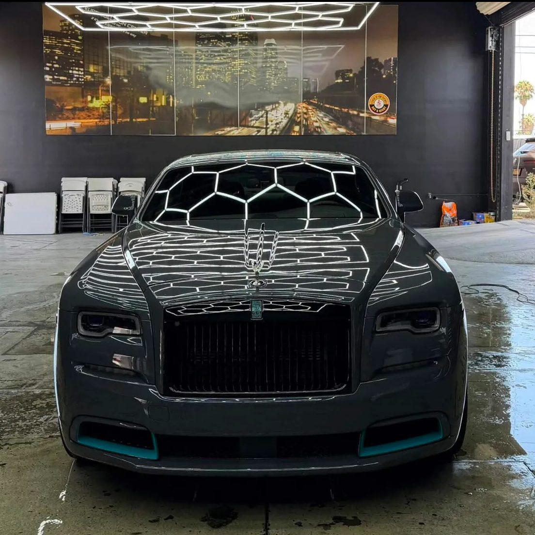 Hexagonal shop lights mirrored across a sealed Rolls-Royce hood